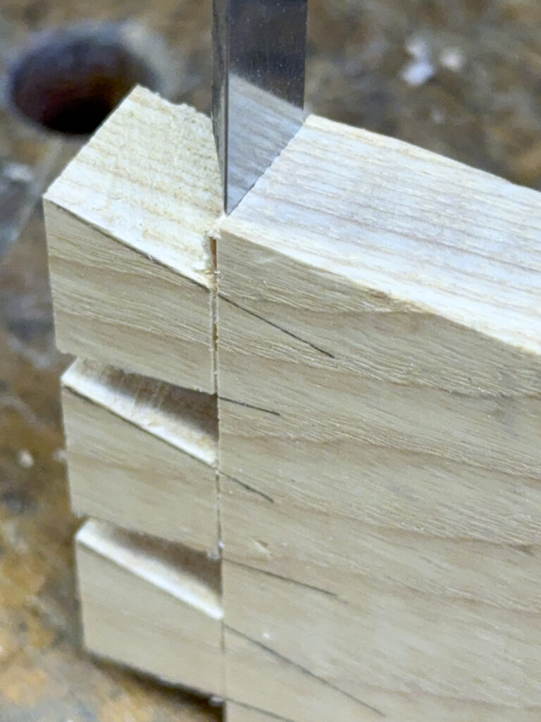 chiseling the cross base line between dovetail sides
