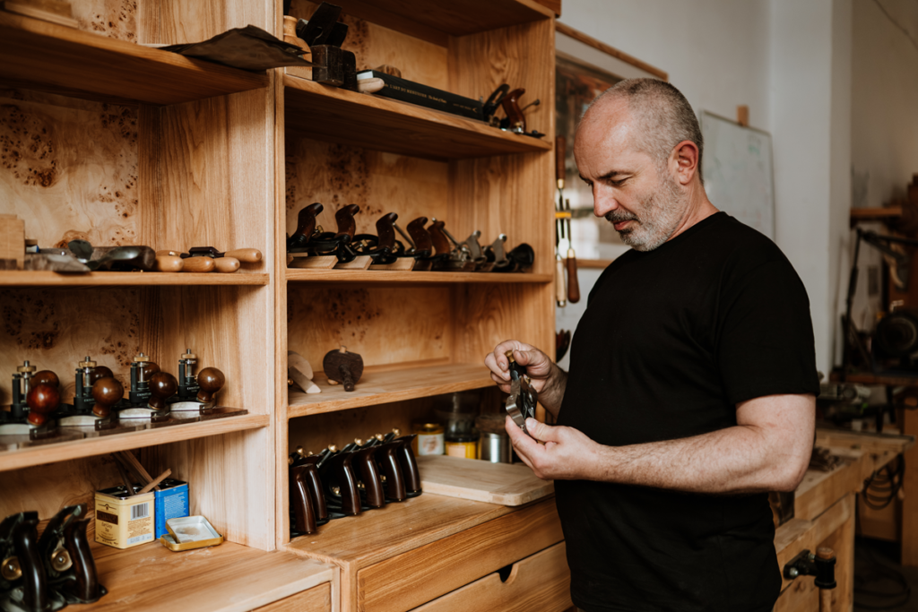 Tom Bensari, mistrz stolarski, w pracowni Bensari Workshop z narzędziami ręcznymi używanymi podczas kursów stolarstwa